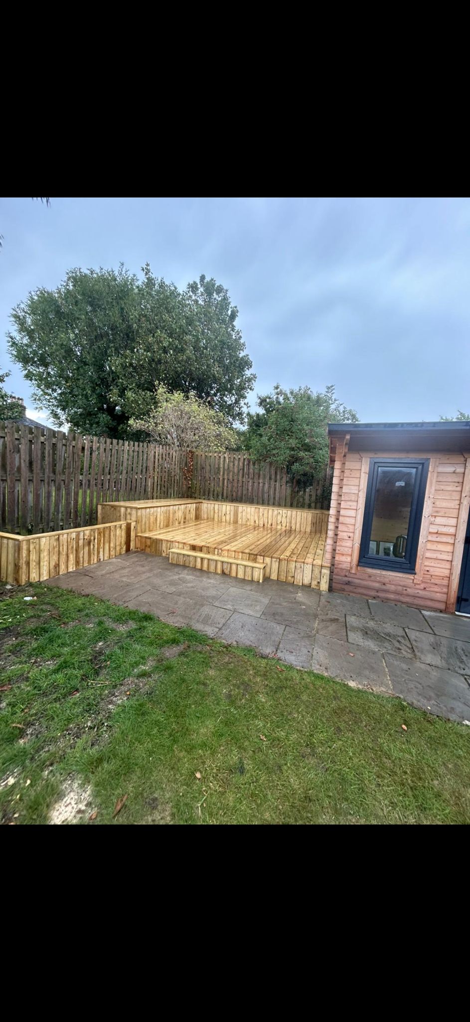 Timber decking and garden room with paving